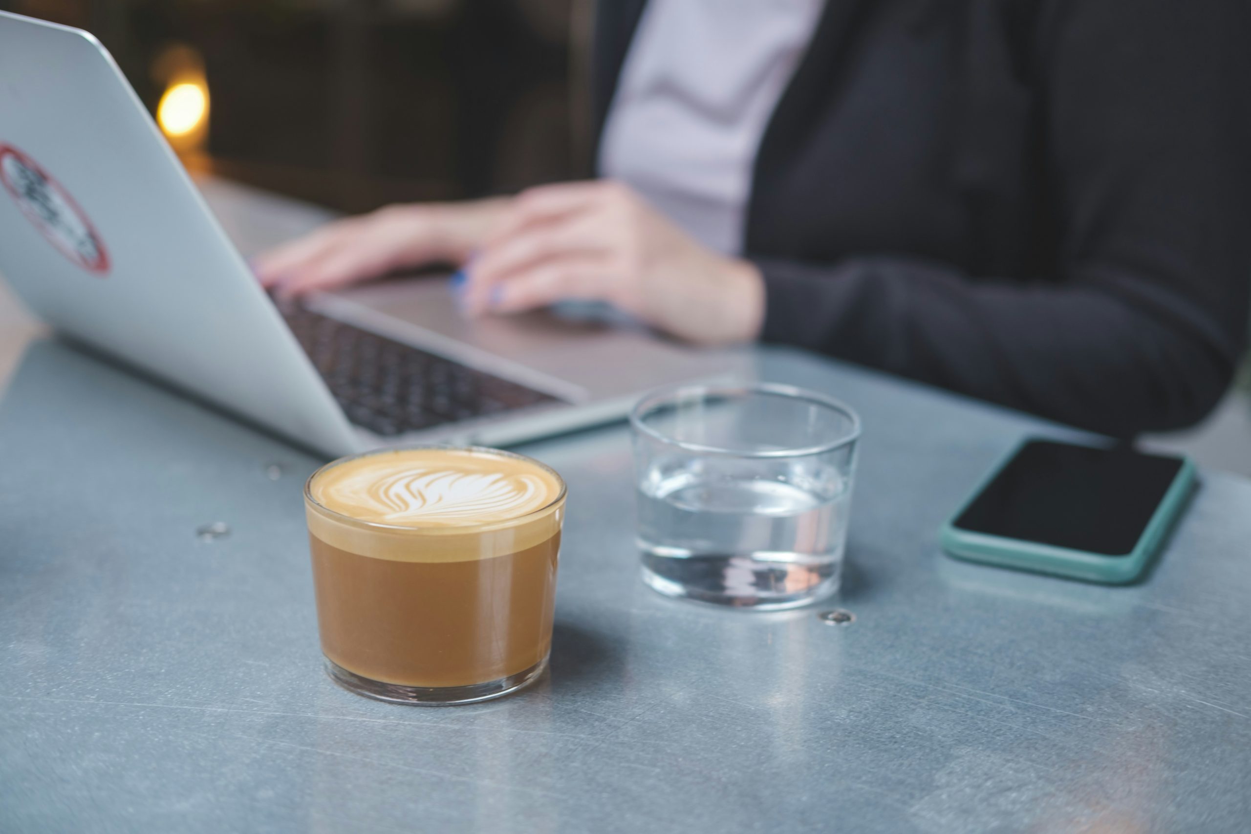 Laptop displaying popular financial apps next to a cup of coffee